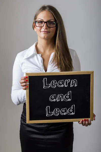 Learn and Lead - Young businesswoman holding chalkboard with tex — Stock fotografie