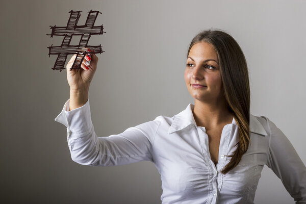 hashmark - Красивая девушка, пишущая на прозрачной поверхности
