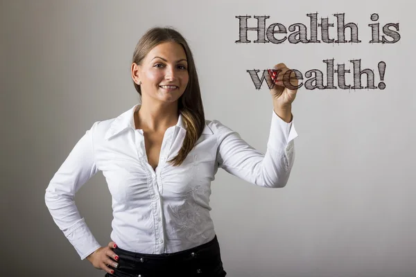 Gesundheit ist Reichtum! - schöne Mädchen schreiben auf transparentem Surfac — Stockfoto