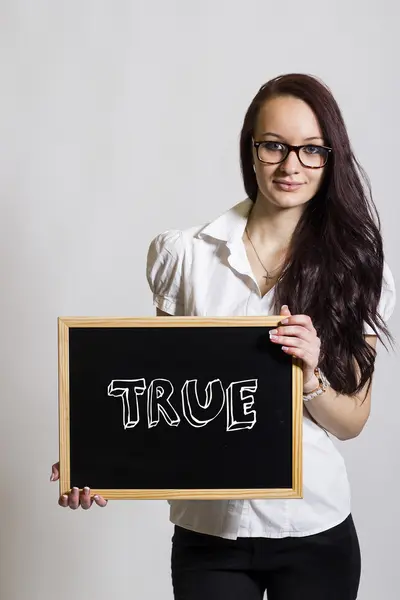 TRUE - Young businesswoman holding chalkboard — Stock Photo, Image