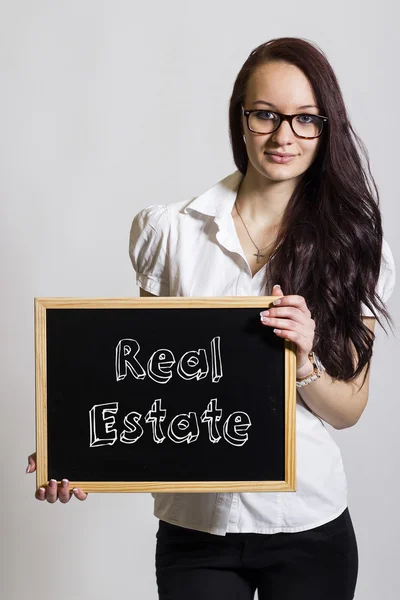 Immobilier - Jeune femme d'affaires tenant un tableau noir — Photo