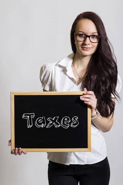 Impostos - Jovem empresária segurando quadro — Fotografia de Stock