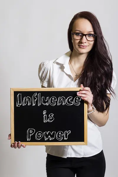 Inflytande är makt - ung affärskvinna holding svarta tavlan — Stockfoto