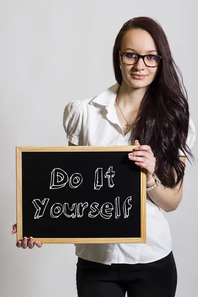 Hazlo tú mismo - Joven empresaria sosteniendo pizarra — Foto de Stock