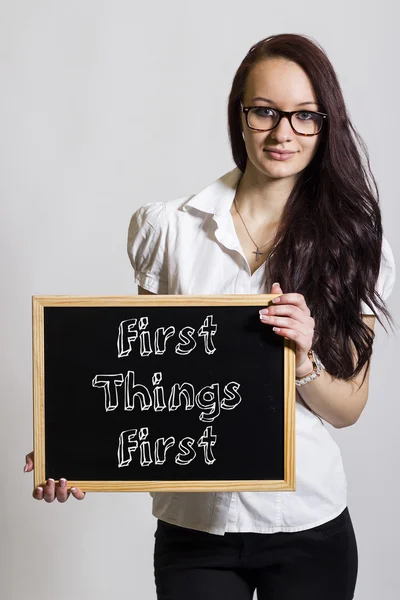 First Things First - Young businesswoman holding chalkboard — Stock Photo, Image