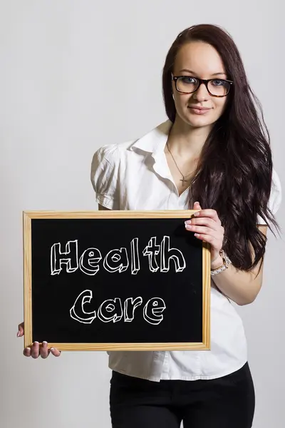 Opieki zdrowotnej - młody bizneswoman gospodarstwa chalkboard — Zdjęcie stockowe