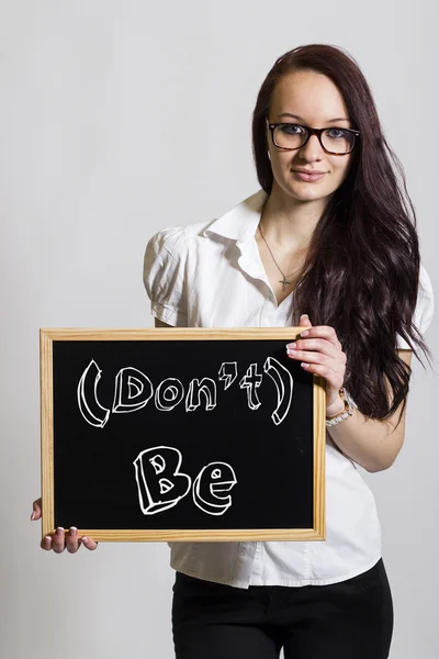 (Don't) Be - Young businesswoman holding chalkboard — Stock Photo, Image