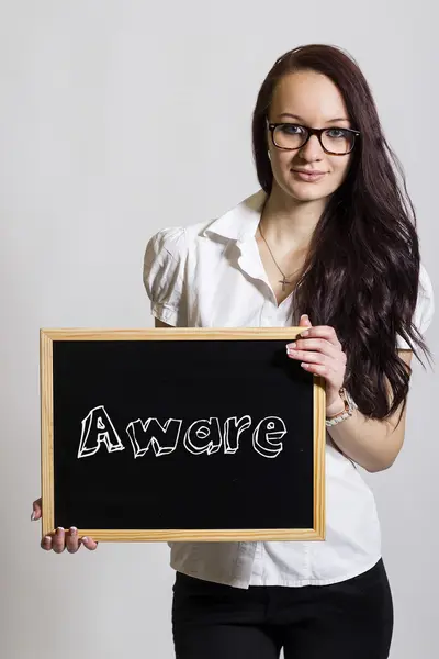 Aware - Young businesswoman holding chalkboard — Stock Photo, Image
