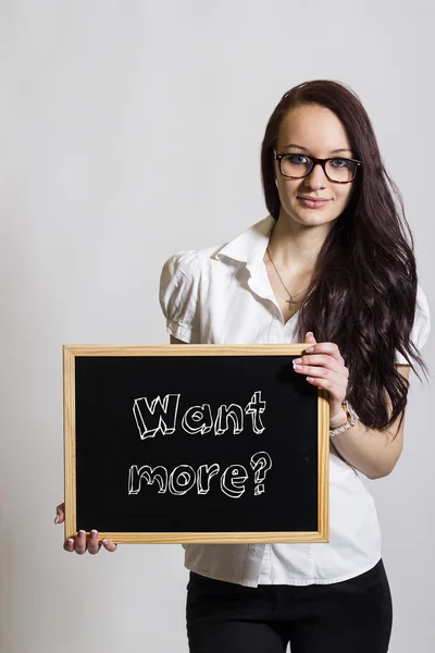 Want more? - Young businesswoman holding chalkboard — Stock Photo, Image