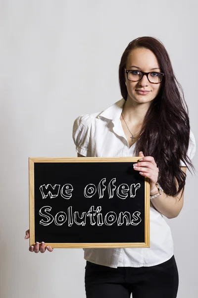 Ofrecemos soluciones - Joven empresaria sosteniendo pizarra — Foto de Stock