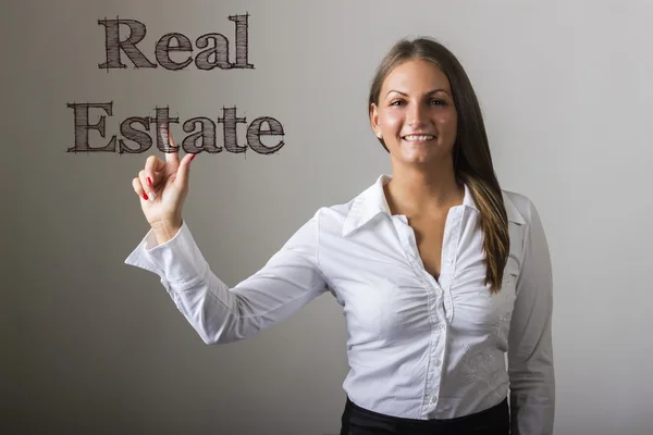 Real Estate - Beautiful girl touching text on transparent surfac — Stock Photo, Image