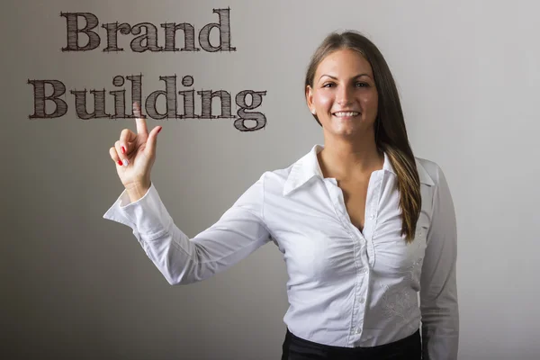 Brand Building - Beautiful girl touching text on transparent sur — Stock Photo, Image