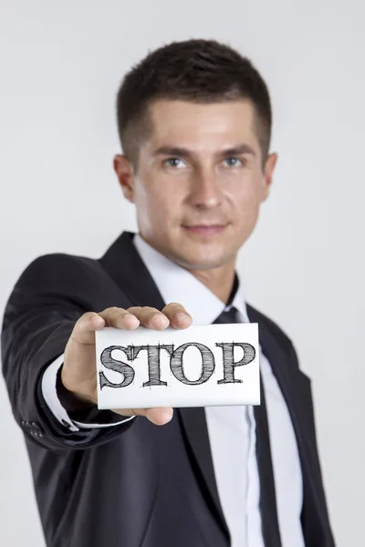 Stoppa - ung affärsman holding ett vitt kort med text — Stockfoto