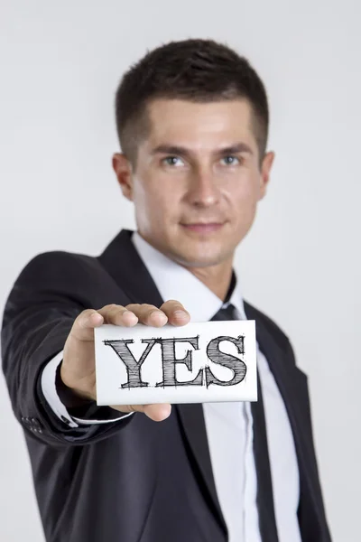 YES - Young businessman holding a white card with text — Stock Photo, Image