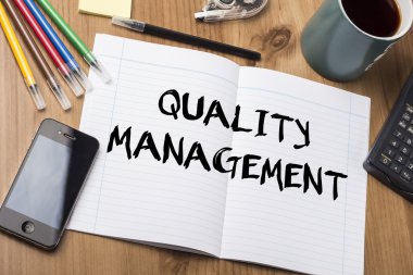 Kalite Yönetimi - Not Defteri ile ahşap masa üzerinde metin