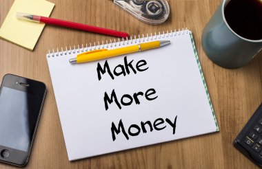 Daha fazla para - Not Defteri ile ahşap masa üzerinde metin