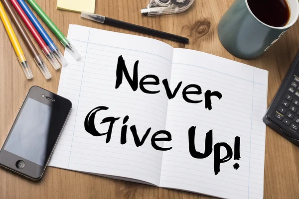 Never Give Up! - Note Pad With Text On Wooden Table