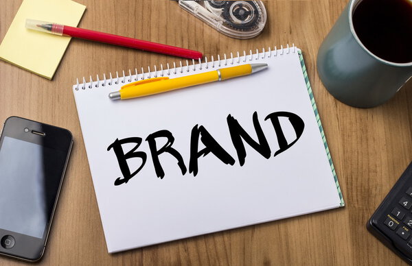 Бренд - блокнот с надписью на деревянном столе
