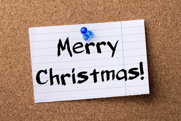 Merry Christmas! - teared note paper  pinned on bulletin board — Stock Photo, Image