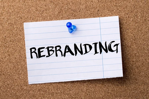 REBRANDING - teared note paper pinned on bulletin board — Stock Photo, Image