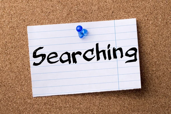 Searching - teared note paper pinned on bulletin board — Stock Photo, Image