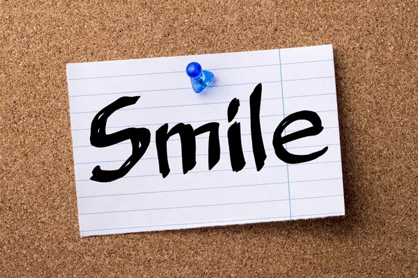 Sonrisa - papel de nota desgarrado fijado en el tablón de anuncios —  Fotos de Stock