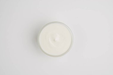 Beyaz tabakta ekşi kremalı tencere.