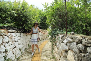 Girit, Yunanistan 'ın güzel dar sokaklarında bir kız yürüyor