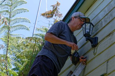Bir adam merdivenden yukarı çıkıp bir ampulü değiştirmek istiyor..