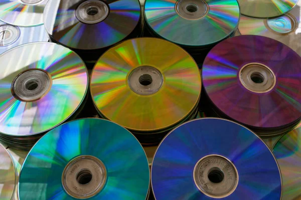 Yığınlar halinde altın, mor, mavi, siyah ve yeşil DVD 'ler