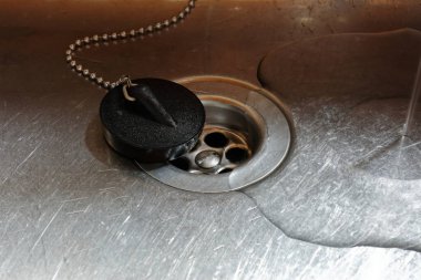 Paslanmaz çelik lavaboda delik deşik edilmiş ve su çekilmiş.