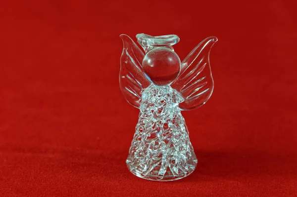 Güzel bir kristal Noel meleği, halesi olan, kırmızı arka planda