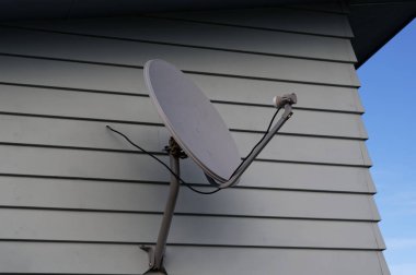 Bir evin yan tarafında parabolik bir uydu anteni.
