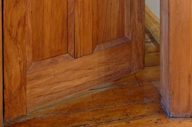 Ahşap bir kapı açık. Sadece bir çatlak. Arkasında ne olduğunu merak ettiriyor.