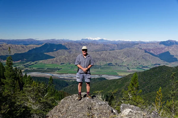 Vadi kayalık bir çıkıntıda duran bir adamın arkasına düşer, gülümser..