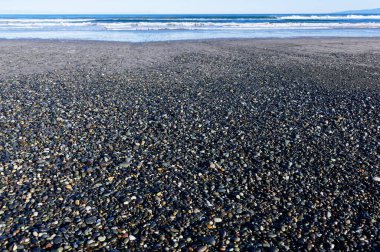 Taşlar ve muhtemelen mücevherler, Gem Stone Sahili, Batı Southland, Yeni Zelanda kıyılarını kaplıyor.