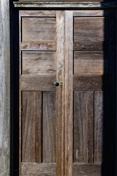 A wooden panel door with a round door handle and a lock