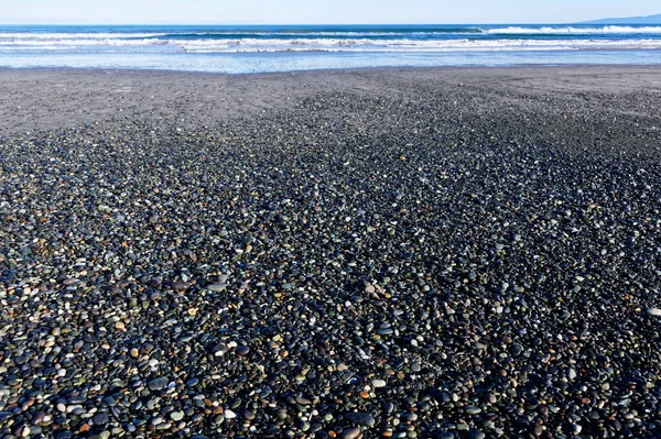 Taşlar ve muhtemelen mücevherler, Gem Stone Sahili, Batı Southland, Yeni Zelanda kıyılarını kaplıyor.