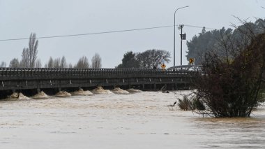 MOTUEKA köprüsünün altında su birikintisi var. Motueka, Yeni Zelanda 17 Temmuz 2021. Motueka Nehri, Yeni Zelanda 'da yaygın sele yol açan sağanak yağmurun ardından çamurlu bir sel ile Motueka köprüsünün altından akar..  