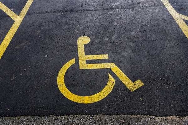 Disabled parking is marked with a yellow disabled sign painted on the road