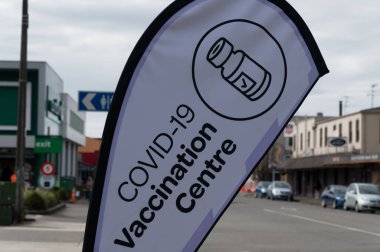 Bir Covid-19 aşı merkezi, Yeni Zelanda 'da bir kaldırım bayrağıyla varlığını duyuruyor.