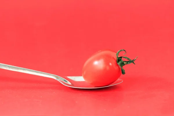 Under the background of pure color small tomato