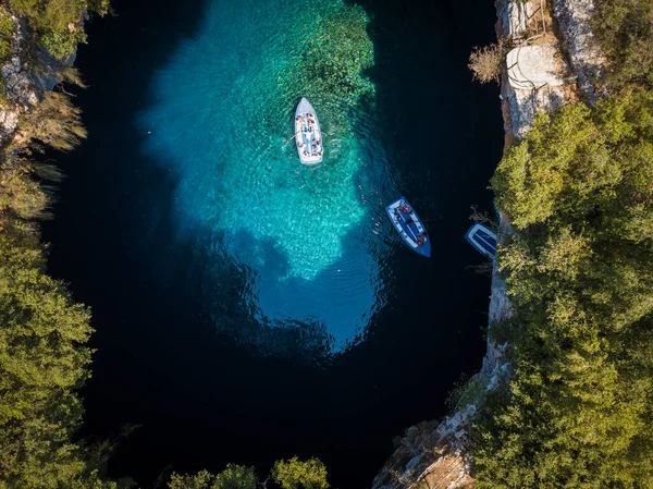 Melissani mağarasında berrak sularda yüzen birkaç tur botu.