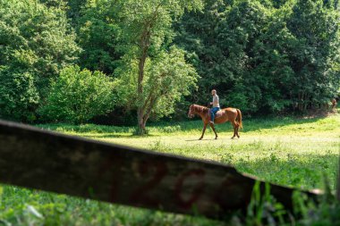 Uzaklarda at üstünde genç bir adam