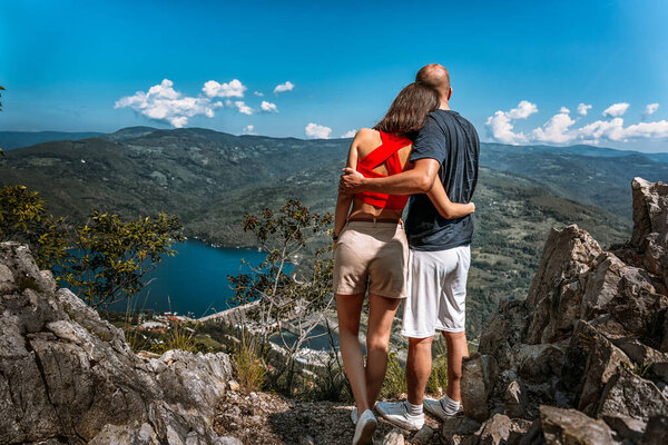 Young couple enjoying a view of Perucac lake and river dam from a magnificent viewpoint in Tara mountain