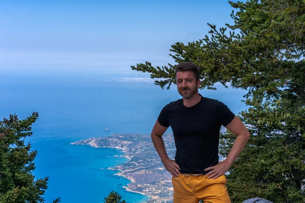 Genç adam Kefalonia 'nın tepesinde Ainos Dağı' nda fotoğraf için poz veriyor.