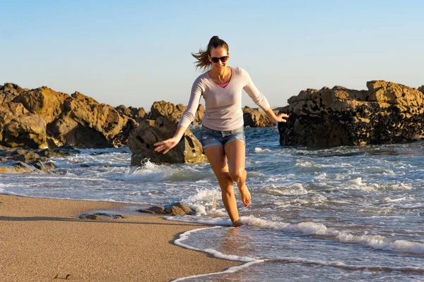 Genç ve güzel bir kadın Portekiz, Matosinhos 'ta Atlantik kıyısında koşuyor.