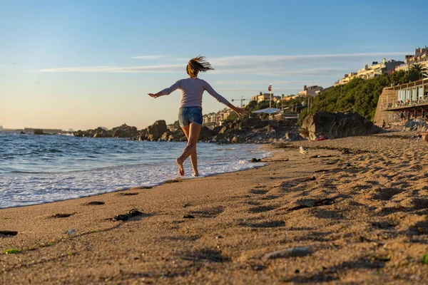 Genç ve güzel bir kadın Portekiz 'in Atlantik kıyısında koşuyor ve gün batımında Matosinhos, Portekiz' de hayatın tadını çıkarıyor.