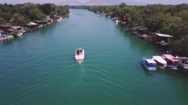 Nehirde huzur içinde yüzen bir teknenin insansız hava aracı görüntüsü
