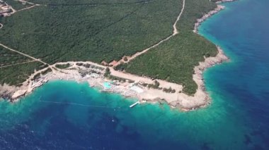 Yüzme havuzu olan bir plaj barının üstündeki hava manzarası.